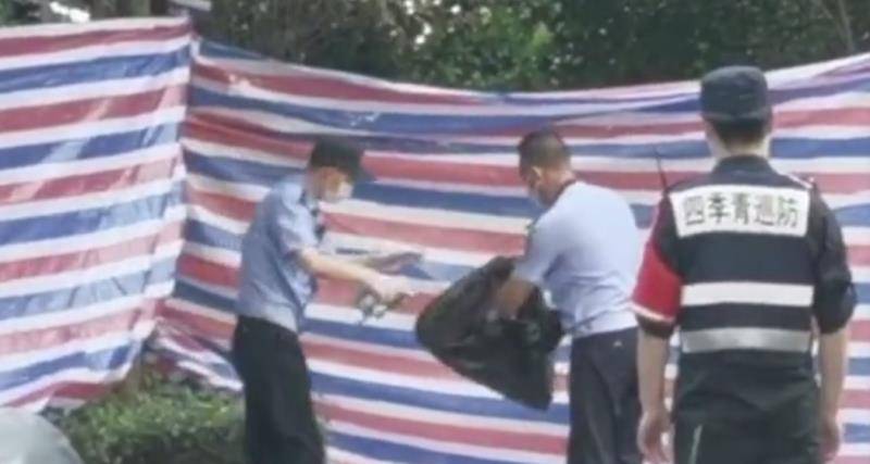 警方现场勘察人员在对化粪池内提取的物品进行冲洗拍照后打包带走。