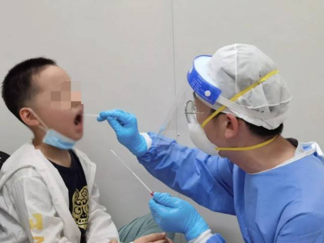 香港大学深圳医院核酸标本采集室内，一位小朋友正在接受核酸标本采集。