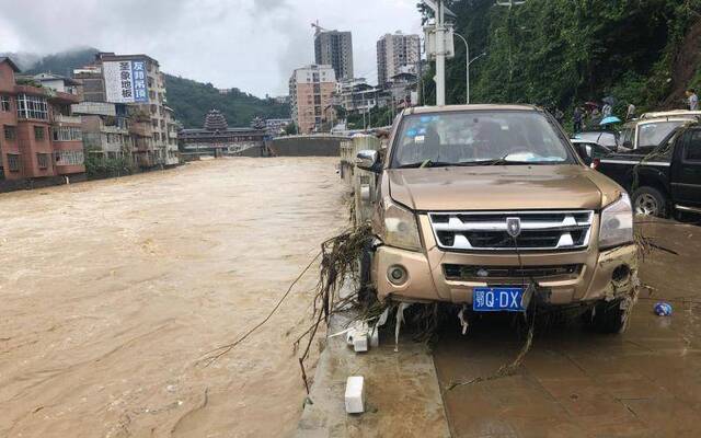 7月26日，建始县广润河发生洪水，几十台车辆被淹，岸边栏杆损毁，不少车辆被冲入河中。新京报记者向凯摄