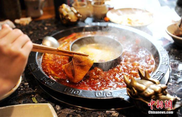 资料图：火锅店内食客正在烫毛肚片。中新社记者刘忠俊摄