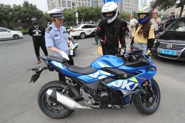 民警对一辆大排量的摩托车进行检查。摄影/新京报记者王贵彬