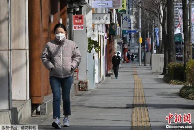 2020年2月27日，一名女子戴着口罩走在韩国大邱街道上。