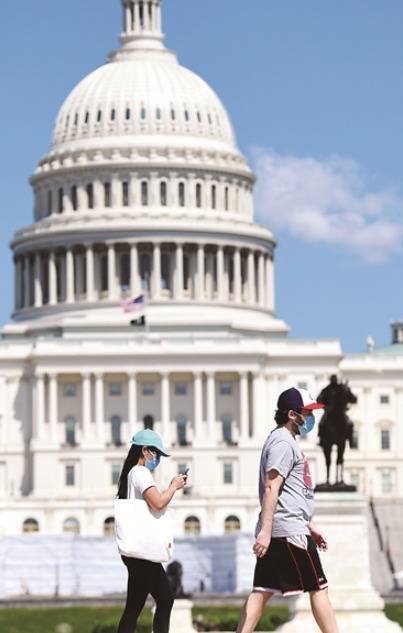 在美国首都华盛顿，戴口罩的行人从国会大厦附近走过。新华社记者刘杰摄