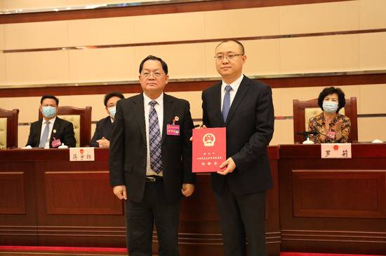 ▲深圳市人大常委会主任骆文智（左）为张勇颁发任命书。