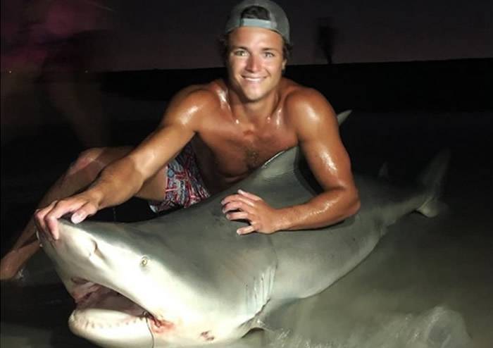 美国纽约长岛曼哈塞青年捕获重近400磅公牛鲨打卡留念即放生