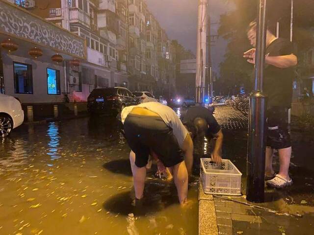 阵雨后多路段落叶堵住排水口，市民自发清理