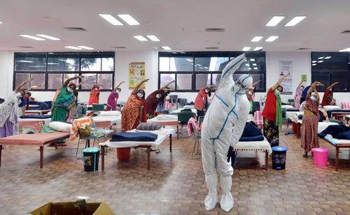  7月24日，医务人员和患者在印度首都新德里的一所新冠治疗中心做瑜伽。新华社发（帕塔·萨卡尔摄）