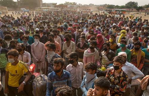  5月18日，在印度新德里郊区的加济阿巴德，准备返乡的农民工排队等待登车。新华社发（贾韦德·达尔摄）