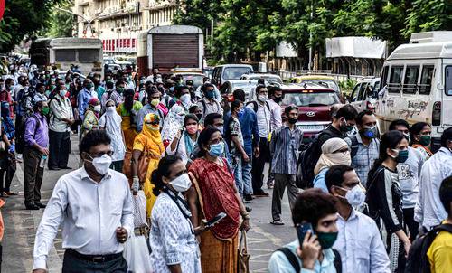  6月9日，佩戴口罩的乘客在印度孟买的公共汽车站候车。新华社发