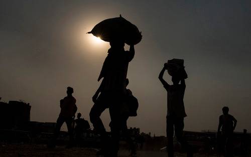  5月18日，在印度新德里郊区的加济阿巴德，头顶行李的农民工准备登上返乡大巴。新华社发（贾韦德·达尔摄）