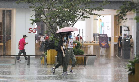 7月31日，一场雷雨突降，行人在五棵松华熙-live广场。