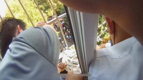 惊险！七岁女童悬挂窗外民警和消防员拆护栏救孩子