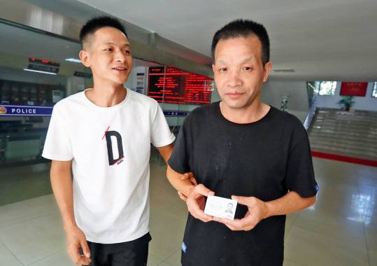 ·8月12日，张玉环（右）在儿子张保仁的陪同下，领取了临时居民身份证。