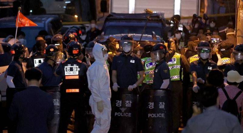 △8月20日晚，在首尔城北区“爱第一”教会前，教徒们阻拦流行病学调查员进入并与警方对峙。
