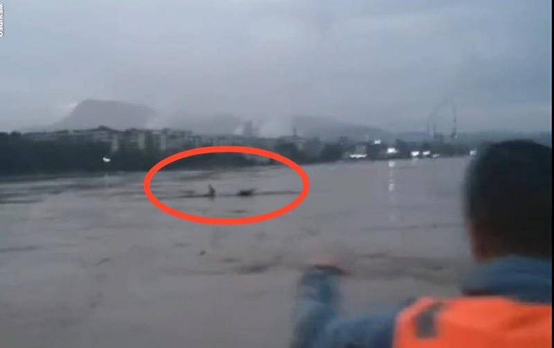 救援人员正在对飘在江上的杨楠（化名）进行施救。视频截图