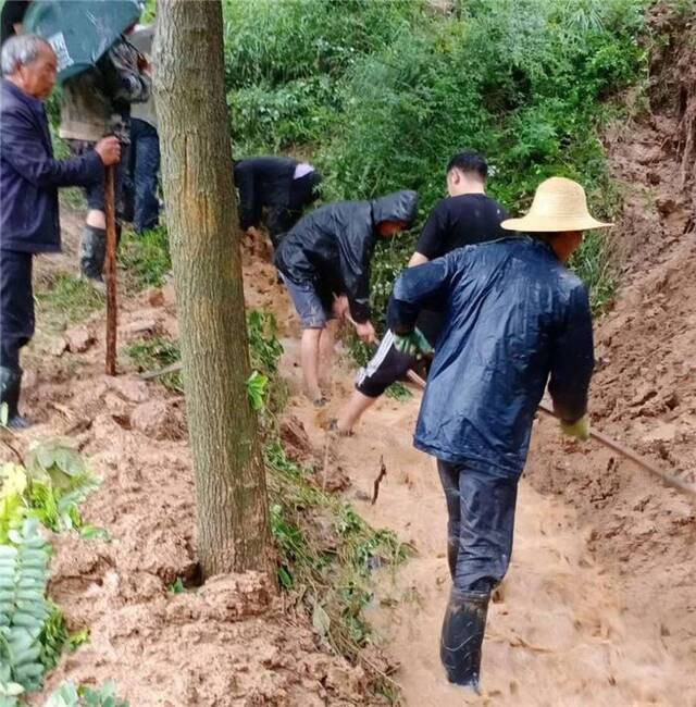 武都区外纳镇纪检干部和群众一起清理淤泥、疏通河道。