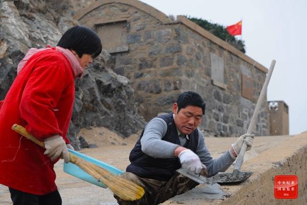 图为王继才、王仕花夫妇在对岛上破损的设施进行维护修补。