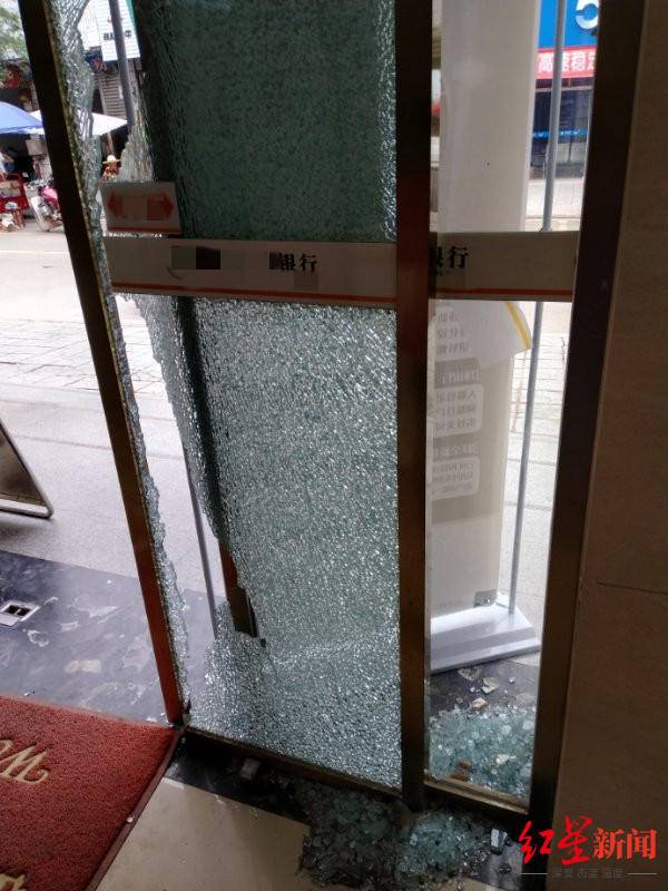 ↑银行的玻璃被男子砸坏。