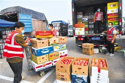 昨日，新发地的蔬菜批发商正在码货。