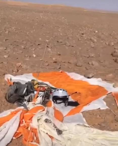 飞行员跳伞后拍摄的画面，可以看到地上的降落伞、头盔、无线电设备等物品。