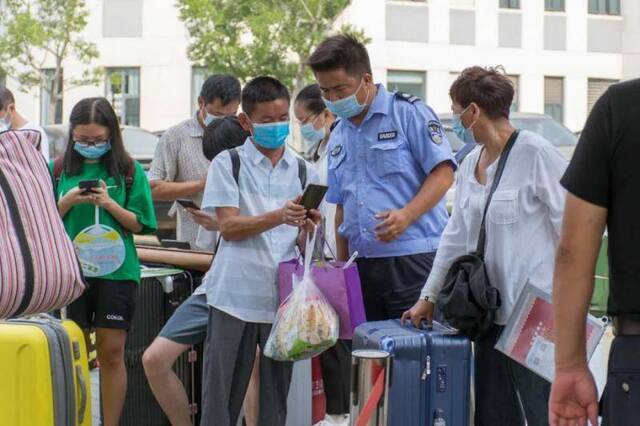 新生在执勤人员的指导下扫码登记（周奕淳摄）