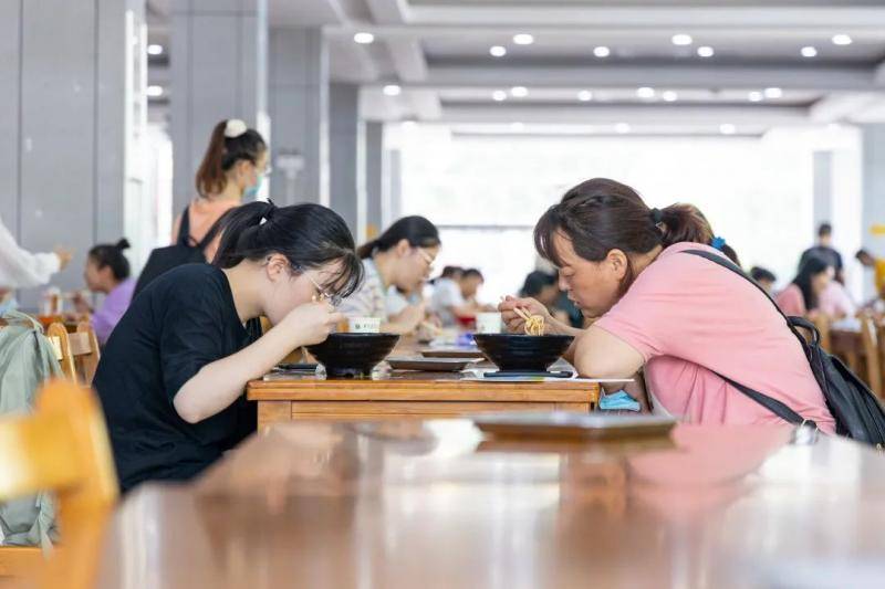 新生与家长正在荟园食堂用餐（包丞摄）