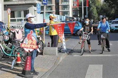 9月10日，延庆区北顺城街和东顺城街交界口，志愿者正在路口指引市民等待红绿灯。新京报记者王飞摄