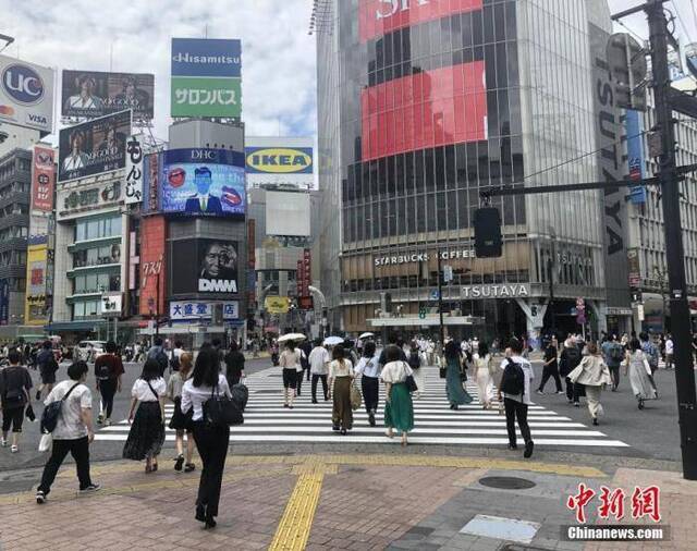 资料图：图为日本民众穿过涩谷车站前的交叉路口。中新社记者吕少威摄