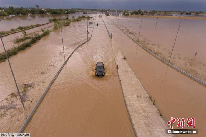 当地时间9月19日，希腊阿特塞亚诺村附近的一辆汽车在洪水泛滥的高速公路行驶。