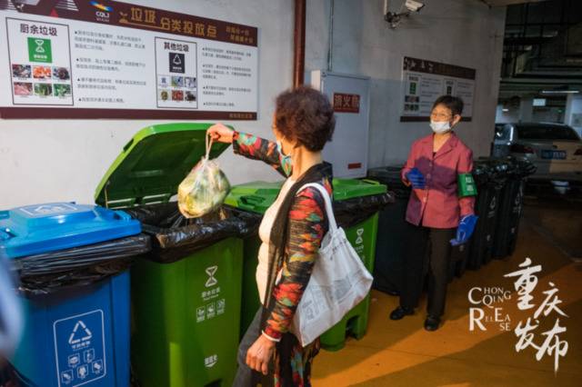 志愿者协助居民对垃圾进行分类投放。（资料图）邹乐摄