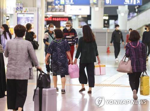 【资料图：9月28日，在釜山火车站，旅客们正前往月台乘坐列车。图源：韩联社】