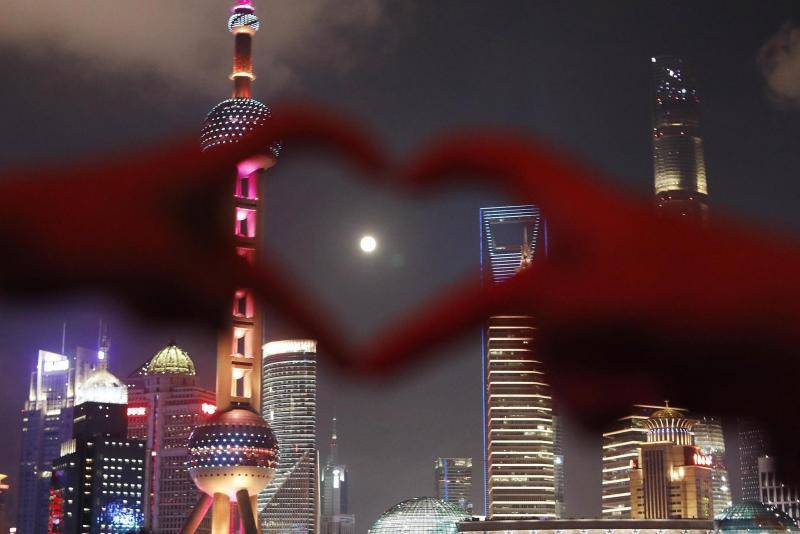 市民和游客在上海外滩滨江步道上拍照、赏月。视觉中国图