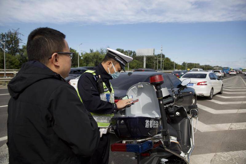 交警正对违法违规司机进行处罚。摄影/新京报记者李凯祥