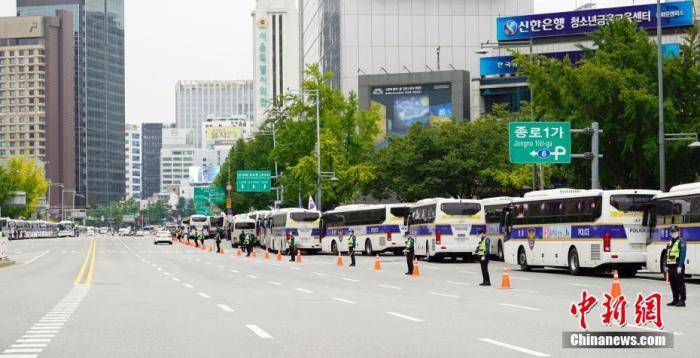 10月3日，韩国多个民间团体发起“免下车”集会，首尔调动大批警力严防疫情。图为大批警察和警车在首尔光化门广场附近，多条路段采取交通管制。中新社记者曾鼐摄