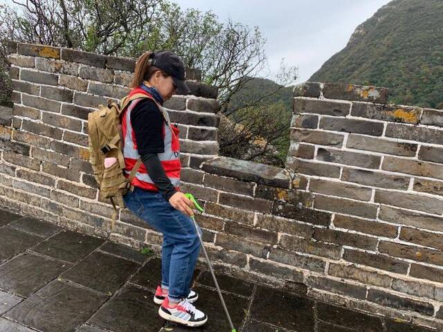 雨后长城湿滑，刘红岩扶着墙壁小心行进。新京报记者倪伟摄