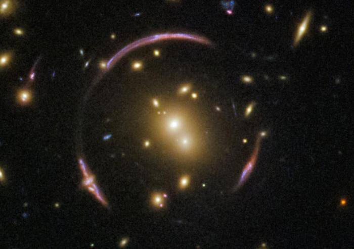 哈勃望远镜拍摄到的爱因斯坦环的图片。图中央是一个星系团，它的质量足够大，以至于严重扭曲了它周围的时空，形成了环绕这个星系团的奇怪环线，这就是爱因斯坦环。图片来源：NASA官网