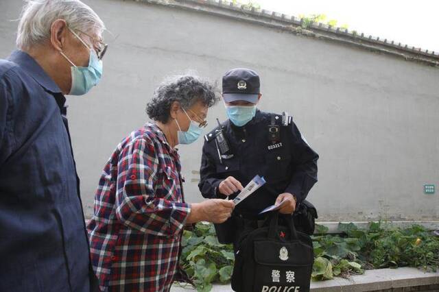 吉祥社区民警刘士琦为社区居民宣传安全知识。新京报记者王飞摄