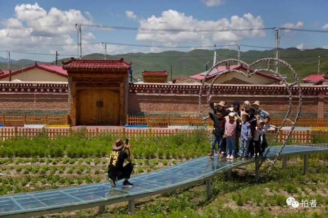 △ 8月1日，尕秀村，游客在村中游玩拍照。通过因地制宜发展旅游业，尕秀村村民获得增收。2018年年底，尕秀村实现全部脱贫。2019年全村接待游客80万人次，户均净收入达3万余元。