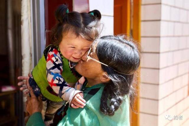 △ 8月1日，尕秀村村民罗卜藏家中，曾祖母玛太亲吻曾孙女。