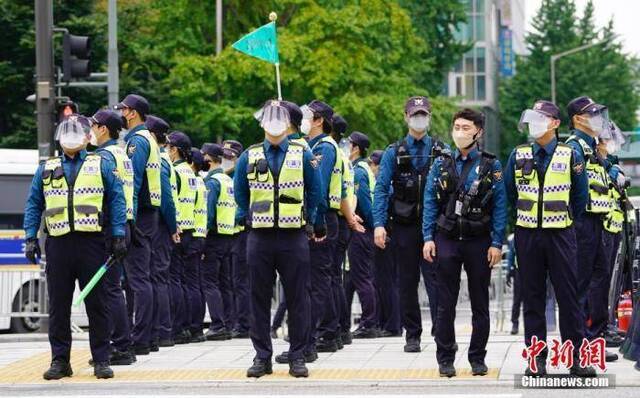 资料图：10月3日，韩国多个民间团体发起“免下车”集会，首尔调动大批警力严防疫情。图为大批警察在首尔光化门广场附近，严防人员聚集。中新社记者曾鼐摄