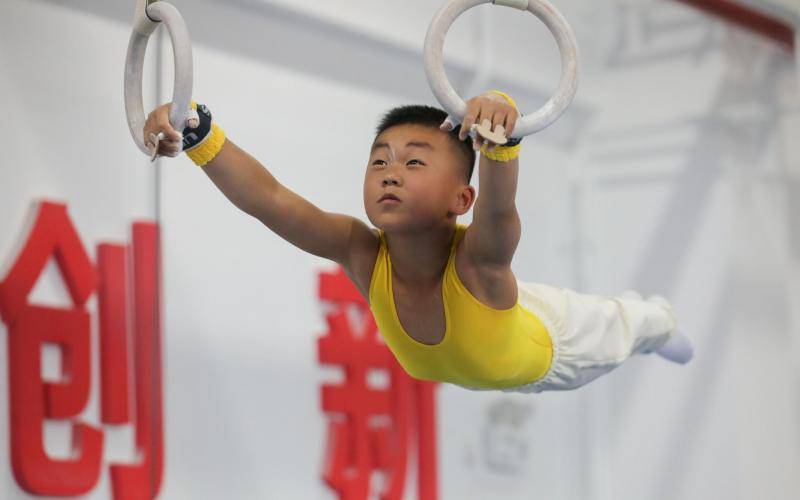吊环比赛中，体操小将身姿矫健。图/北京市体育竞赛管理中心