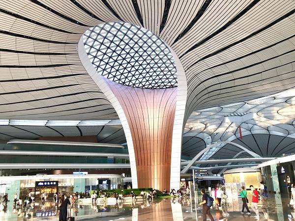 拥有世界规模最大的单体机场航站楼的北京大兴国际机场，被誉为“世界级工程奇迹”。建成一年来，机场客流量突破1000万人次。图为2020年9月12日，旅客在机场内穿行。（图片来源：视觉中国）