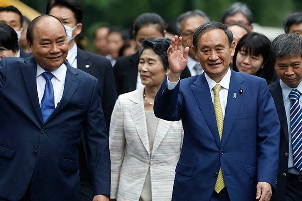 当地时间2020年10月19日，越南河内，越南总理阮春福（左）欢迎来访的日本首相菅义伟和夫人。人民视觉图