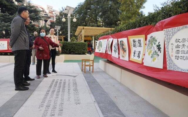 科学园南里六区的中心广场设计极具“奥运特色”，地面铺设了“冬奥运动项目介绍”，旁边挂着居民的书画作品。摄影/新京报记者王飞