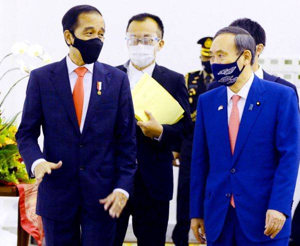 日本首相菅义伟（右）20日在茂物会晤印尼总统佐科。（欧洲新闻图片社）