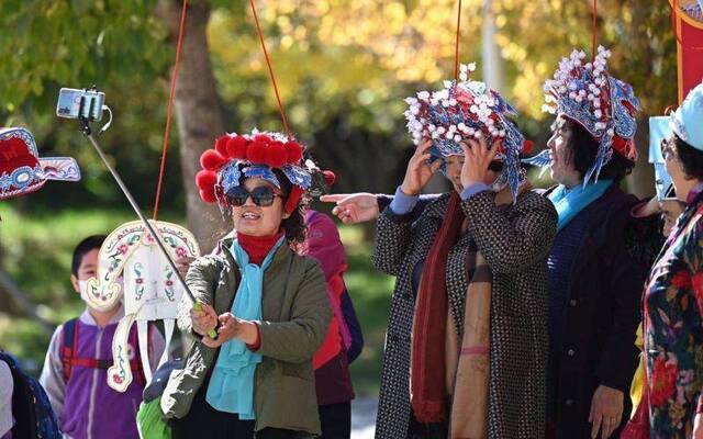 北京园博园内，观众体验戏装戏服并自拍留念。摄影/新京报记者陶冉