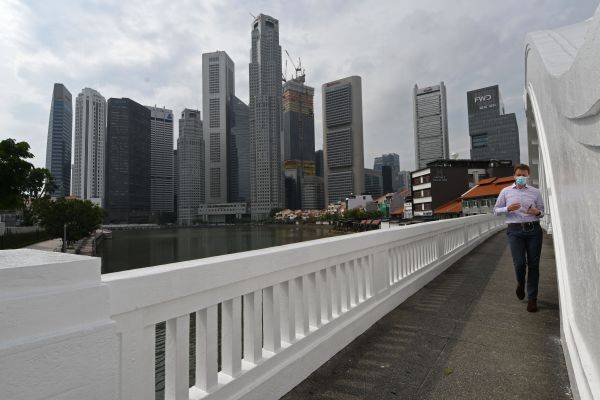 10月14日，一名男子步行通过新加坡市区的一座桥梁。（新华社）