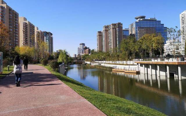 朝阳区亮马河畔建，市民在健身步道上散步。新京报记者黄哲程摄