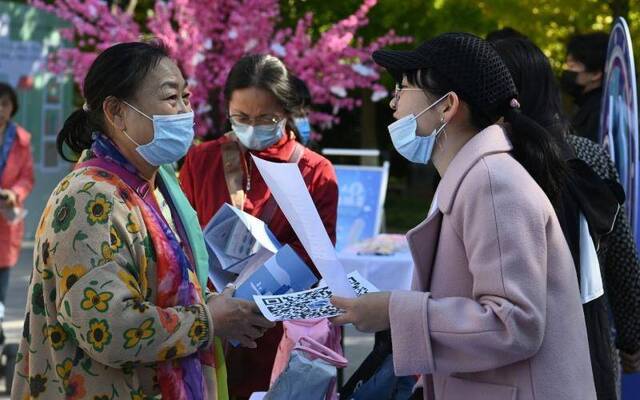 10月17日，国奥社区居委会，社区居民（左）向工作人员了解人口普查的情况。新京报记者陶冉摄