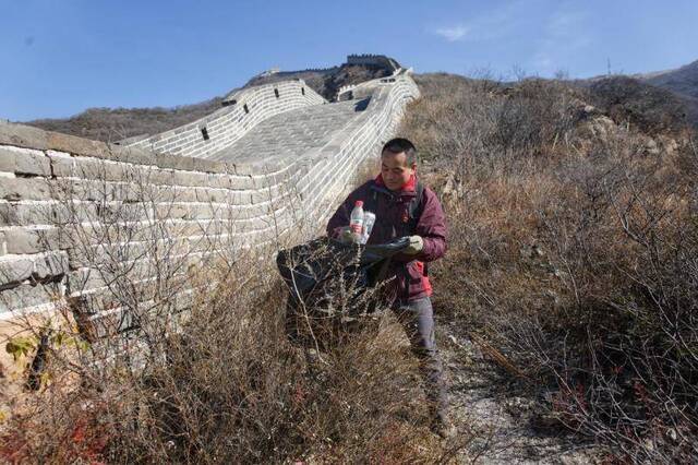 张杰在长城各处捡拾游客遗留的垃圾。新京报记者郑新洽摄